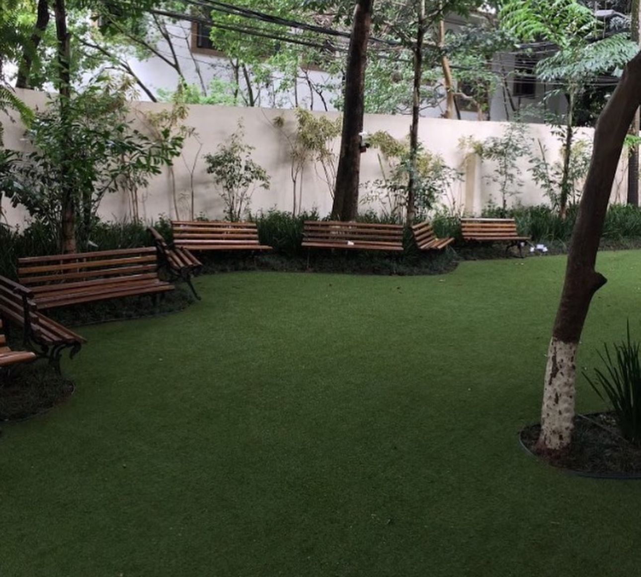 Jardim com bancos e gramado sintético